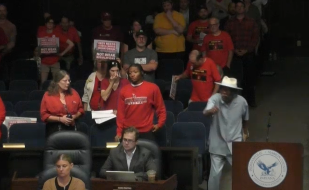 A city resident seen shouting at officials, demanding a stronger data center moratorium.